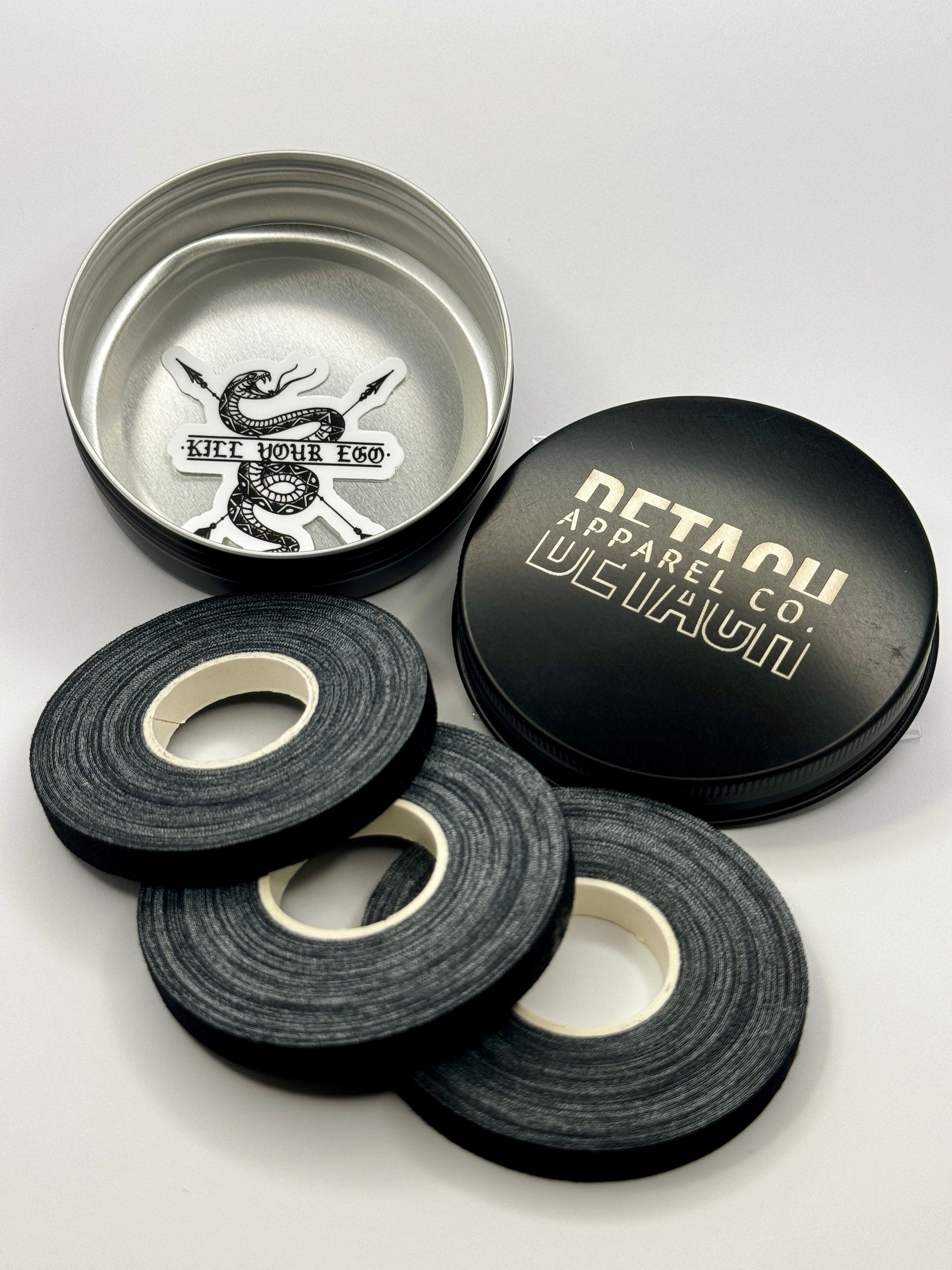 Three rolls of finger tape and metal tin